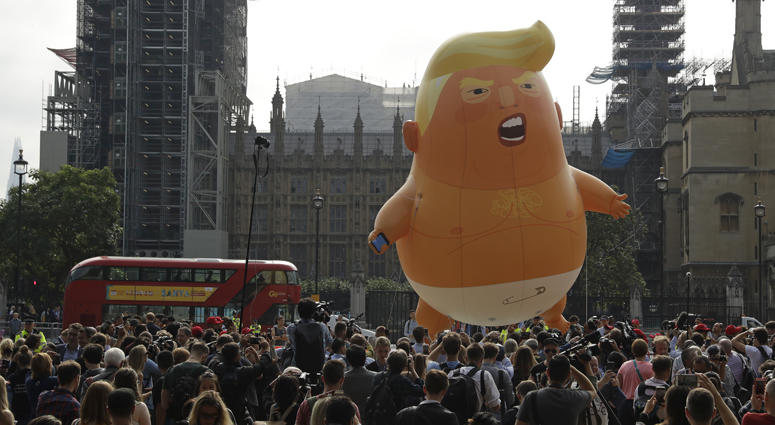 A six-meter high cartoon baby blimp of U.S. President Donald Trump is flown as a protest against his visit, in Parliament Square backdropped by the scaffolded Houses of Parliament and Big Ben in London, England, Friday, July 13, 2018. Baby Trump Balloon