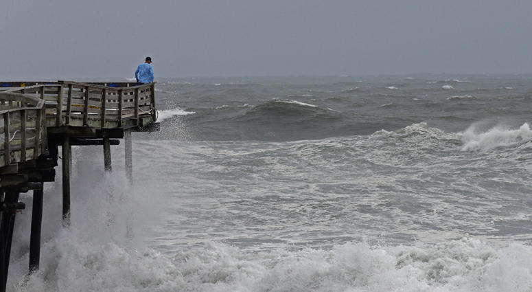 An onlooker checks out the heavy surf at the Avalon Fishing Pier in Kill Devil Hills, N.C., Thursday, Sept. 13, 2018 as Hurricane Florence approaches the east coast. Hurricane Florence