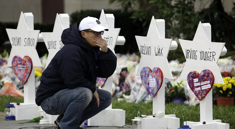 A person pauses in front of Stars of David with the names of those killed in a deadly shooting at the Tree of Life Synagogue, in Pittsburgh, Monday, Oct. 29, 2018.