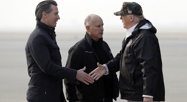President Donald Trump greets California Gov.-elect Gavin Newsom as he arrives on Air Force One at Beale Air Force Base for a visit to areas impacted by the wildfires, Saturday, Nov. 17, 2018, at Beale Air Force Base, Calif., as Gov. Jerry Brown, stands a President Trump California