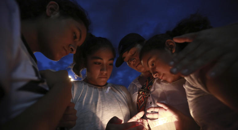 People gather in Juarez, Mexico, Saturday, Aug. 3, 2019, in a vigil for the 3 Mexican nationals who were killed in an El Paso shopping-complex shooting. El Paso shooting