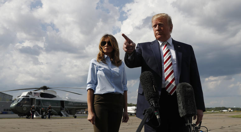 President Donald Trump, with first lady Melania Trump, speaks to the media before boarding Air Force One in Morristown, N.J., Sunday, Aug. 4, 2019. President Trump shootings