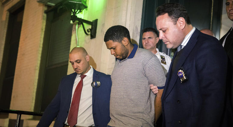 Police officers escort Randy Rodriguez Santos from the 5th Precinct to a vehicle bound for a hospital for evidence collection, Saturday, Oct. 5, 2019, in New York. Randy Rodriguez Santos Chinatown