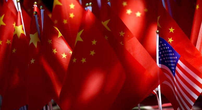 In this Sunday, Sept. 16, 2018, photo, an American flag is displayed together with Chinese flags on top of a trishaw in Beijing. China Tariffs