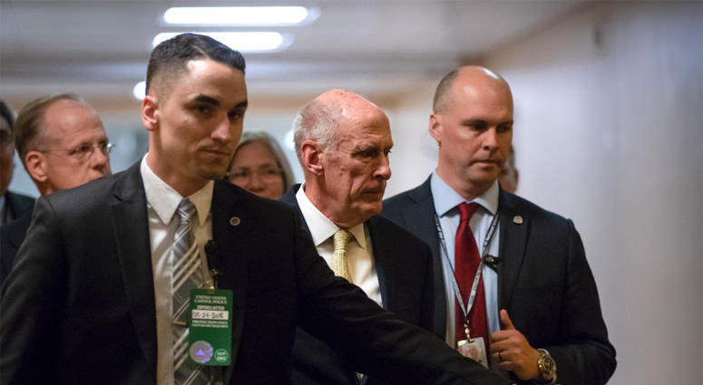 National Intelligence Director Dan Coats, center, is surrounded by security as he departs the Capitol after House and Senate lawmakers from both parties met for a classified briefing about the federal investigation into President Donald Trump's 2016 campa DOJ Meeting On Spy Allegations