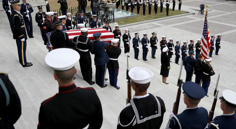 A U.S. military honor guard team carries the flag draped casket of former U.S. President George H. W. Bush from the U.S. Capitol December 5, 2018 in Washington, DC. George H.W. Bush