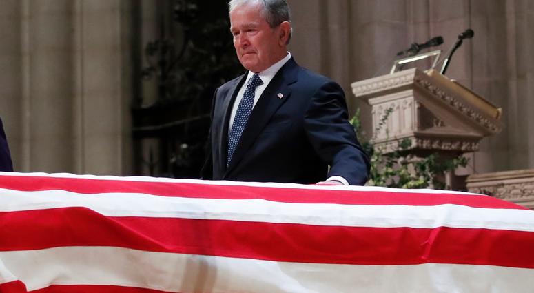– Former President George W. Bush touches the casket of his father, former President George H.W. Bush, at the State Funeral at the National Cathedral, Wednesday, Dec. 5, 2018, in Washington. George H.W. Bush