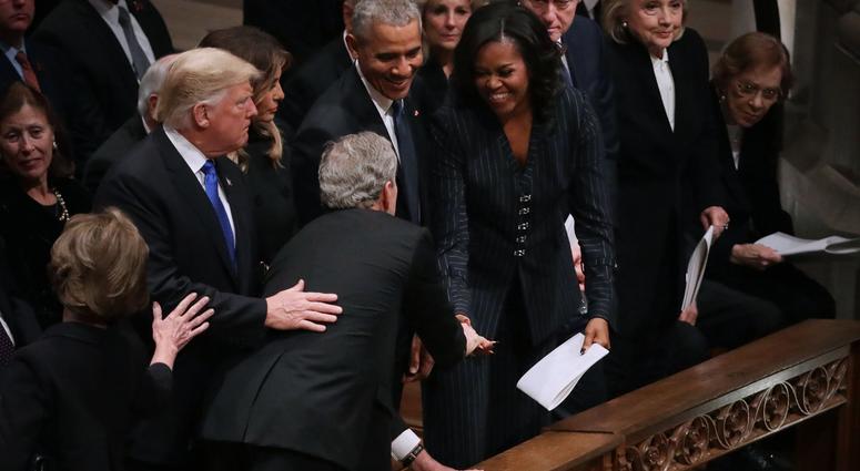 Former U.S. President George W. Bush (C) leans across President Donald Trump and first lady Melania Trump to greet fellow former presidents Barack Obama, Bill Clinton and former first ladies Rosalynn Carter, Hillary Clinton and Michelle Obama. George H.W. Bush