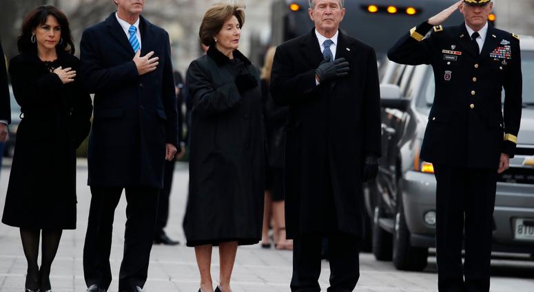 From right, former President George W. Bush, second from right, former first lady Laura Bush, Neil Bush and Sharon Bush, stand as the flag-draped casket of former President George H.W. Bush is carried by a joint services military honor guard. George H.W. Bush