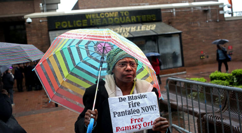 An activist who goes by the name Sista Shirley, 62, from Staten Island, holds up a sign as a line of people awaits entry to the trial of Officer Daniel Pantaleo at One Police Plaza on May 13, 2019 Daniel Pantaleo trail