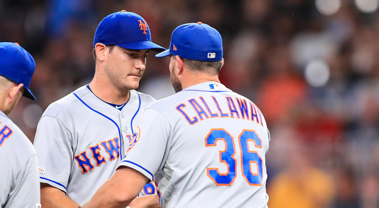 Seth Lugo #67 hands the game ball to Mickey Callaway #36 of the New York Mets in the seventh inning during the game against the Atlanta Braves at SunTrust Park on August 14, 2019 in Atlanta, Georgia. Mickey Callaway and Seth Lugo