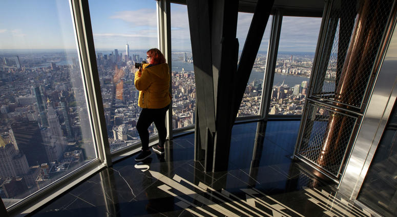 A woman takes a photograph inside the newly renovated 102nd floor observatory of the Empire State Building on October 10, 2019 Empire State Building Observatory