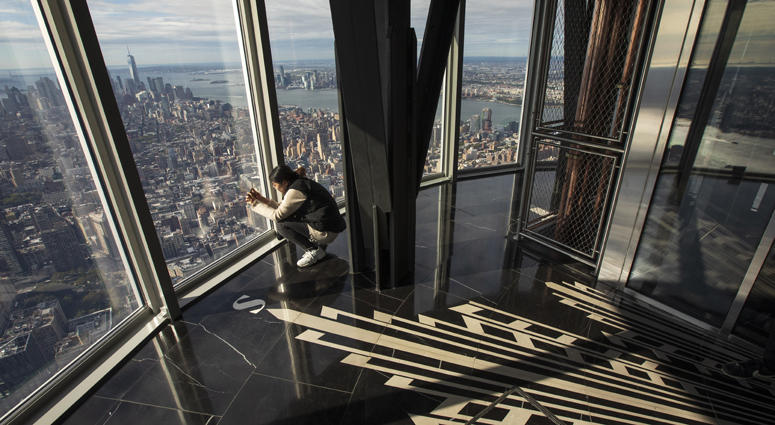 A woman takes in views of Manhattan from the newly renovated 102nd-floor observatory of the Empire State Building on October 10, 2019. Empire State Building Observatory