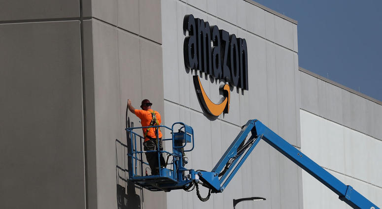 A worker makes repairs to a wall at a new Amazon fulfillment center on August 10, 2017 in Sacramento, California. Amazon Headquarters