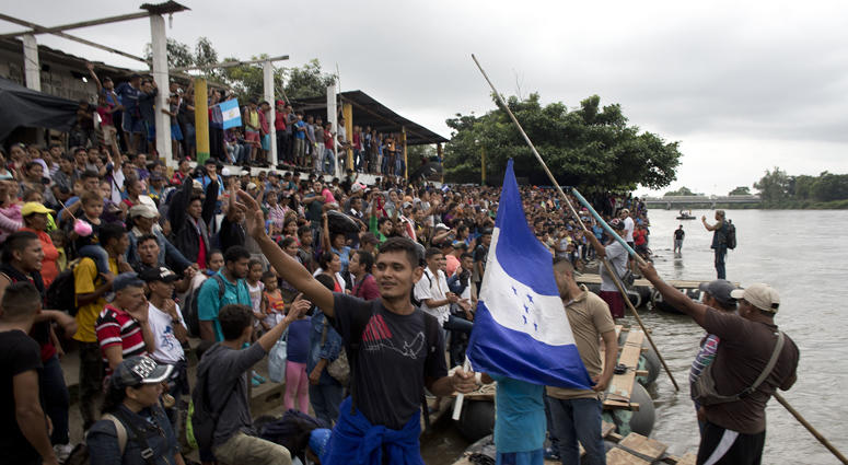 Hundreds of Honduran migrants stand at the shore of the Suchiate river on the border between Guatemala and Mexico, in Tecun Uman, Guatemala, Thursday, Oct. 18, 2018. Guatemala Caravan