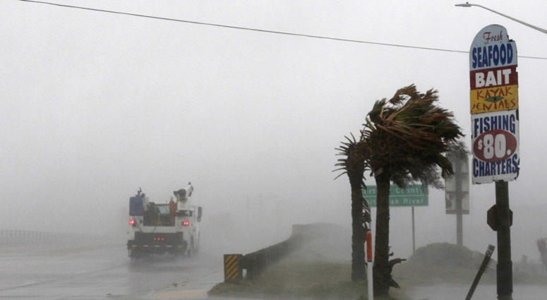 A work truck drives on Hwy 24 as the wind from Hurricane Florence blows palm trees in Swansboro N.C., Thursday, Sept. 13, 2018. Hurricane Florence
