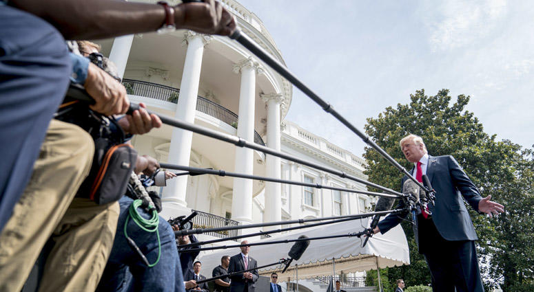 President Donald Trump speaks to members of the media before boarding Marine One on the South Lawn at the White House in Washington, Friday, Aug. 17, 2018, for a short trip to Andrews Air Force Base, Md., and then on to Southampton, LI for a fundraiser. President Donald Trump