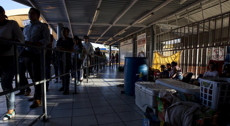 People wait in line to cross into the United States. Border Port of Entry