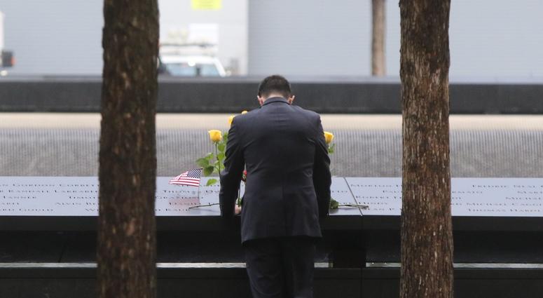 A man looks at names etched into granite, parts of the memorial pool for the North Tower prior to the ceremonies
