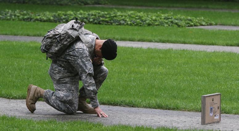 Army Sgt. Edwin Morales of the Bronx bows in honor for his cousin Ruben Correa