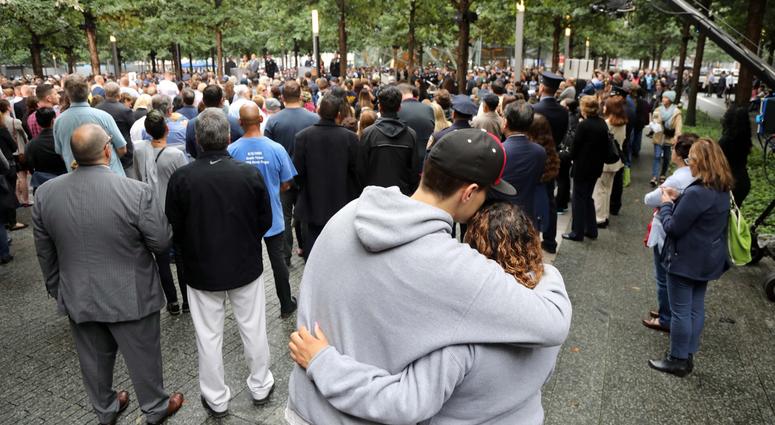 A couple hug as they listen to the names of those who perished on 9/11.