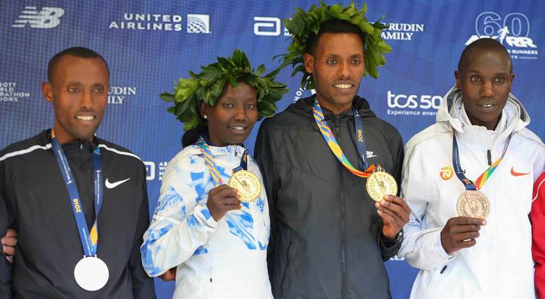 Mens winner Lelisa Desisa of Ethiopia (center) and womens winner Mary Keitany of Kenya pose during the medal ceremony with Shura Kitata of Ethiopia (left) and Geoffrey Kamworor of Kenya (far right) after the New York City Marathon. NYC Marathon