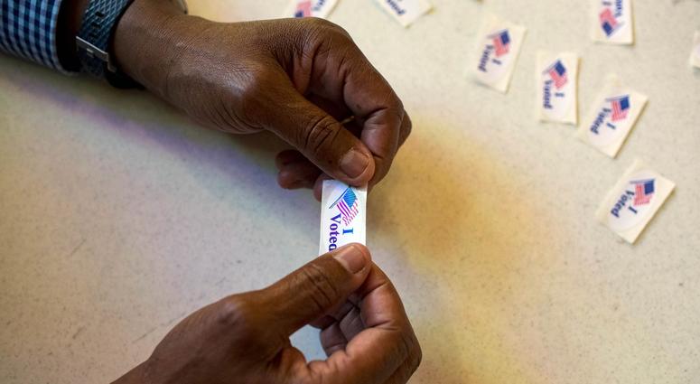 Election official Thomas Shaw holds an \"I Voted\" sticker ready to hand to voters at the Cathedral of Praise in Nashville on Tuesday, Nov. 6, 2018. Election Day