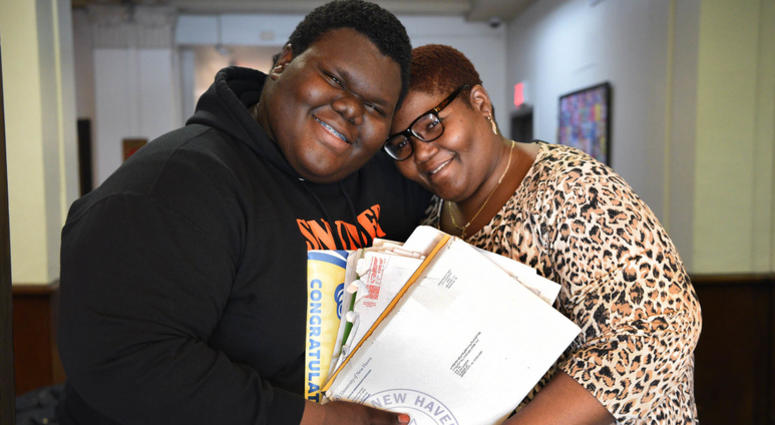 Formerly homeless student Dylan Chidick of Jersey City, NJ and his mother Khadine Phillip, hold his seventeen acceptance letters from college. Dylan Chidick