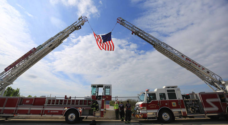 A motorcade carries the body of Marine Staff Sgt. Christopher Slutman, who was killed in a roadside bomb in Afghanistan, from the Dover Air Force Base to New York City on Monday morning. Firefighters Honor Fallen Marine