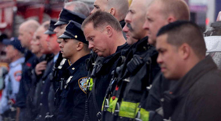 Members of the New York City Fire Department and New York City Police Department stand outside the Joseph Lucchese Funeral Home in the Bronx April 21, 2019 as the hearse containing the body of FDNY member and U.S. Marine Christopher Slutman arrives. Firefighters Honor Fallen Marine