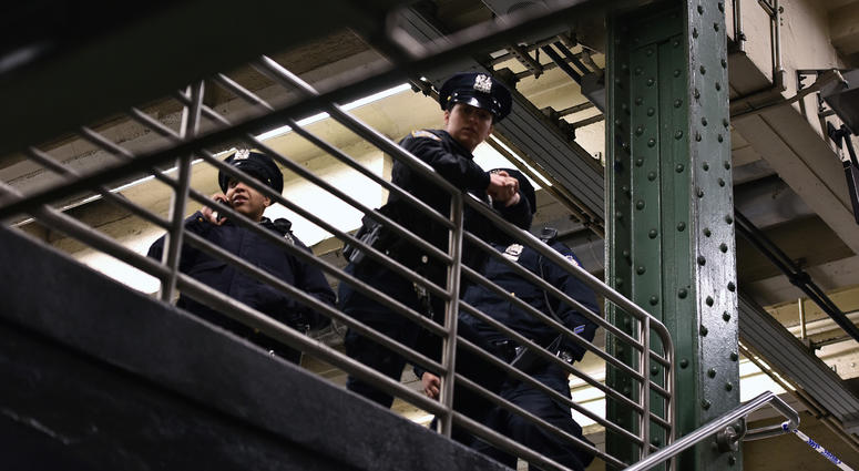 NYPD officers stand at the top of stairs leading to the subway passageway on 42nd Street between 7th and 8th avenues. NYPD officers subway