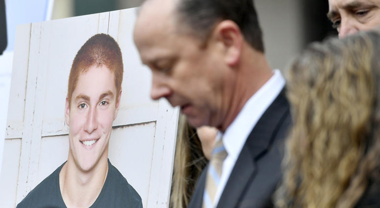 A large photo of Timothy Piazza next to his father Jim Piazza as he speaks about the importance of passing the anti-hazing legislation named after his son outside of the Centre County Courthouse on Friday, March 23, 2018 in Bellefonte, Pa. Timothy Piazza