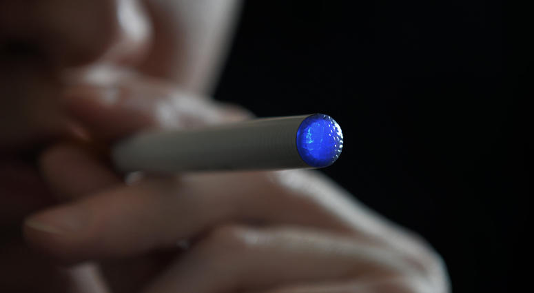 A person smoking an electronic cigarette. E-cigarette