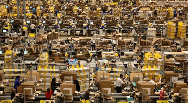 Amazon workers packing orders on the warehouse floor. Amazon warehouse