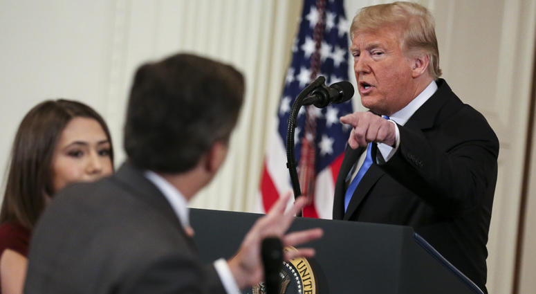 A White House staff member, left, tries to take away the microphone from CNN White House correspondent, Jim Acosta, during an exchange with President Donald Trump after giving remarks a day after the midterm elections on November 7, 2018 in Washington, DC Jim Acosta, Donald Trump