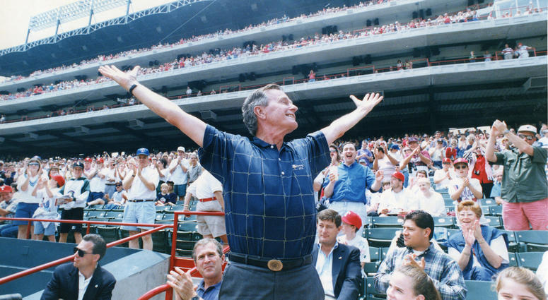In this undated photo, former President George H.W. Bush acknowledges the crowd at Rangers Ballpark in Arlington, Texas. George H.W. Bush