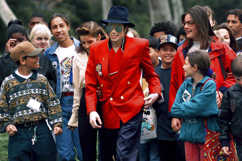 Michael Jackson and Lisa Marie Presley, behind him at left, walk with children that were invited guests at his Neverland Ranch