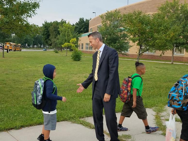 Superintendent at work Ed Graff shaking kids' hands