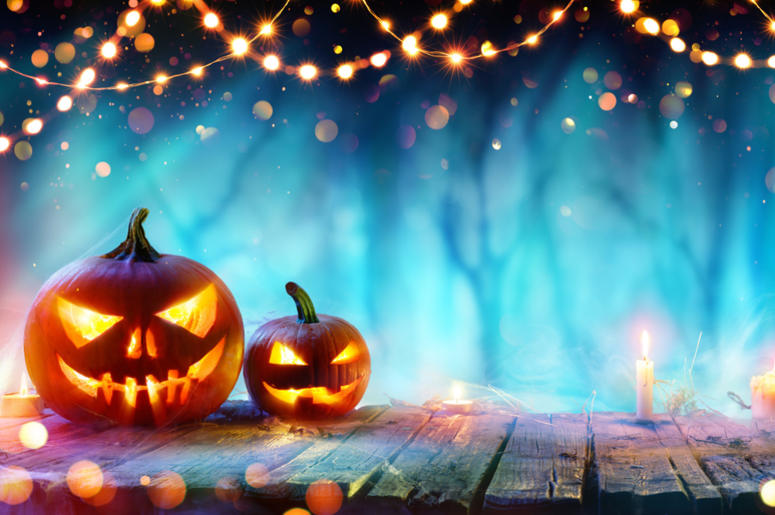 Halloween Party - Jack O' Lanterns And String Lights On Table In Misty Forest Halloween Party - Jack O' Lanterns And String Lights On Table In Misty Forest