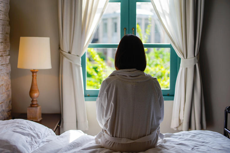 Woman Sitting On A Bed