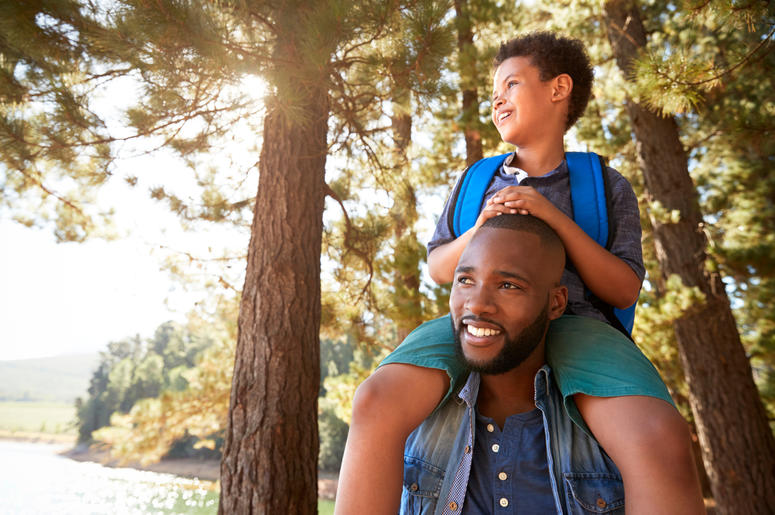 Father Walking In Woods Carrying Son Father Walking In Woods Carrying Son