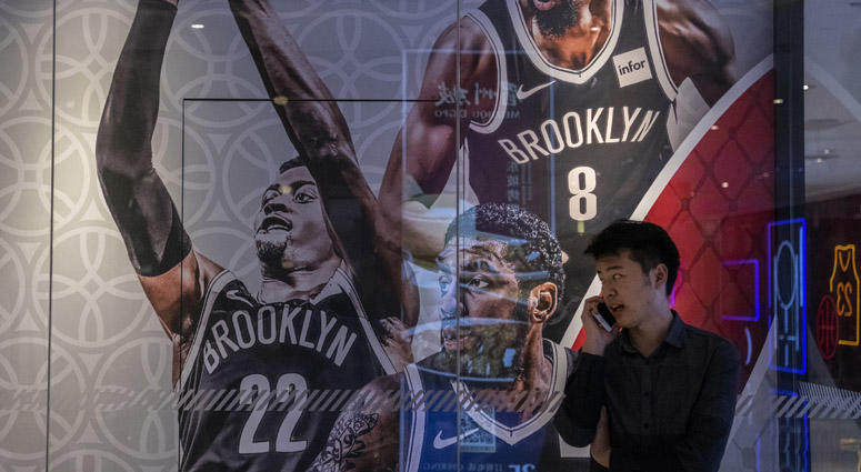 A Chinese man talks on his phone next to a billboard showing players from the Brooklyn Nets outside the NBA flagship retail store on Oct. 9, 2019 in Beijing. A Chinese man talks on his phone next to a billboard showing players from the Brooklyn Nets outside the NBA flagship retail store on Oct. 9, 2019 in Beijing.