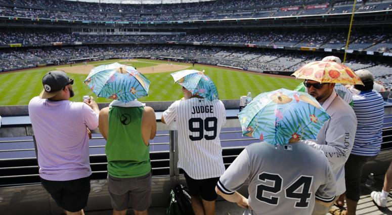 Fans use umbrella hats to protect themselves from the sun during the sixth inning of a baseball game between the New York Yankees and the Colorado Rockies Saturday, July 20, 2019, in New York. Fans use umbrella hats to protect themselves from the sun during the sixth inning of a baseball game between the New York Yankees and the Colorado Rockies Saturday, July 20, 2019, in New York.