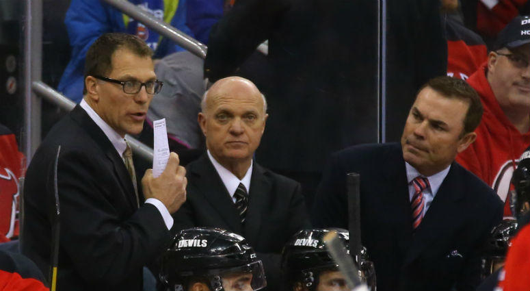 Jan 9, 2015; Newark, NJ, USA; New Jersey Devils coach Scott Stevens (L) and Adam Oates (R) confer with general manager Lou Lamoriello (C) against the New York Islanders at the Prudential Center. Mandatory Credit: Adam Hunger-USA TODAY Sports