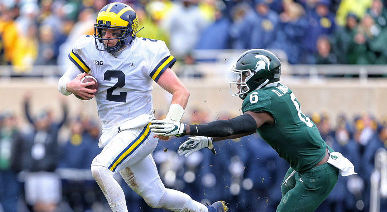 Michigan quarterback Shea Patterson runs though the tackle of Michigan State safety David Dowell on Oct. 20, 2018, at Spartan Stadium in East Lansing, Michigan. Michigan quarterback Shea Patterson runs though the tackle of Michigan State safety David Dowell on Oct. 20, 2018, at Spartan Stadium in East Lansing, Michigan.