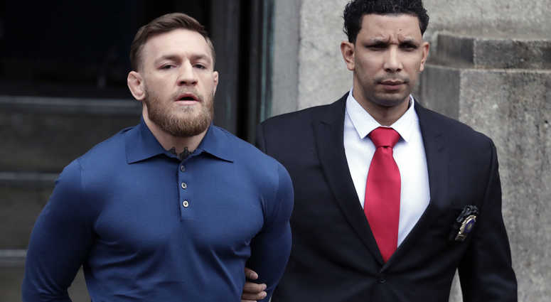 Ultimate fighting star Conor McGregor, left, is led by an official to an unmarked vehicle while leaving the 78th Precinct of the New York Police Department, Friday, April 6, 2018, in the Brooklyn borough of New York. McGregor is facing criminal charges in Ultimate fighting star Conor McGregor, left, is led by an official to an unmarked vehicle while leaving the 78th Precinct of the New York Police Department, Friday, April 6, 2018, in the Brooklyn borough of New York. McGregor is facing criminal charges in
