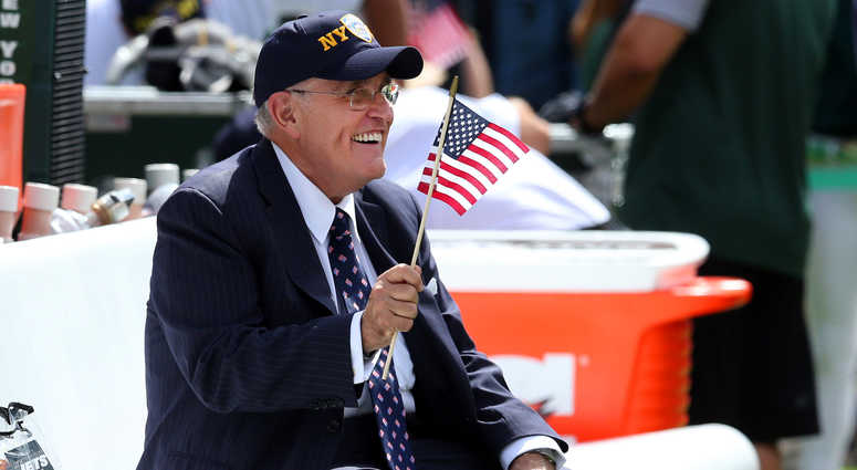 Sep 11, 2016; East Rutherford, NJ, USA; New York City former mayor Rudy Giuliani waves an American flag while sitting on the Jets bench before a game between the New York Jets and the Cincinnati Bengals at MetLife Stadium. Sep 11, 2016; East Rutherford, NJ, USA; New York City former mayor Rudy Giuliani waves an American flag while sitting on the Jets bench before a game between the New York Jets and the Cincinnati Bengals at MetLife Stadium.