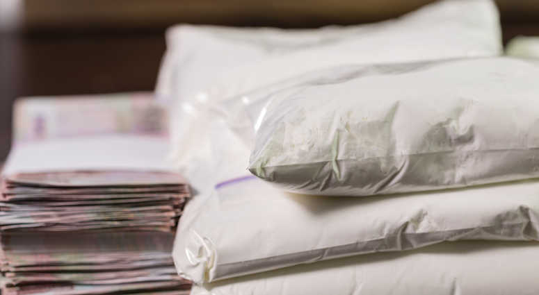 Stash of heroin drugs on table in transparent bags with money in piles Stash of heroin drugs on table in transparent bags with money in piles