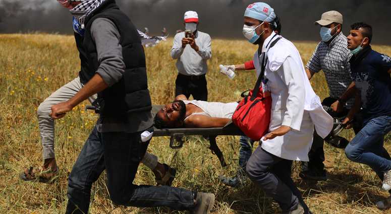 GAZA, April 6, 2018 (Xinhua) -- Palestinian protesters carry an injured man during clashes on the Gaza-Israel border, east of Gaza City on April 6, 2018. Hundreds of Palestinian demonstrators began Friday to set fire to dozens of car tires near the border GAZA, April 6, 2018 (Xinhua) -- Palestinian protesters carry an injured man during clashes on the Gaza-Israel border, east of Gaza City on April 6, 2018. Hundreds of Palestinian demonstrators began Friday to set fire to dozens of car tires near the border