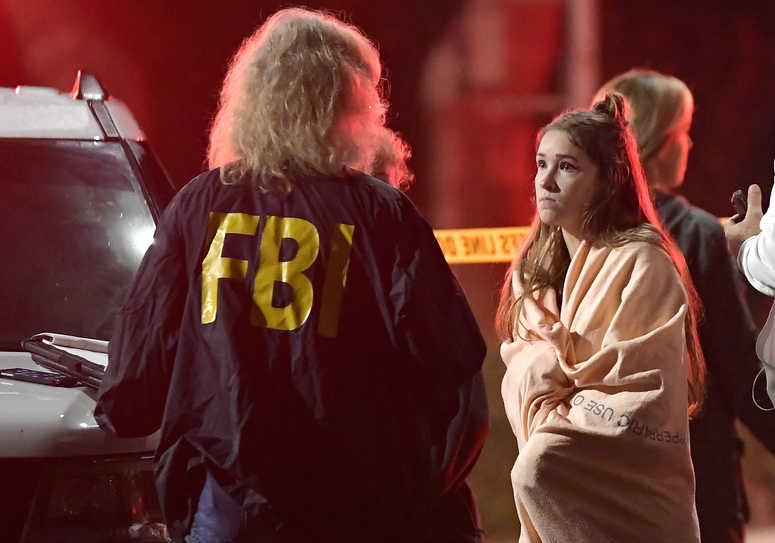 An FBI agent talks to a potential witness as they stand near the scene Thursday, Nov. 8, 2018, in Thousand Oaks, Calif. where a gunman opened fire. An FBI agent talks to a potential witness as they stand near the scene Thursday, Nov. 8, 2018, in Thousand Oaks, Calif. where a gunman opened fire.